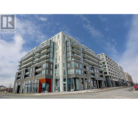 A large multi-story building with a mix of glass and solid panels, with a red entrance, is under construction.