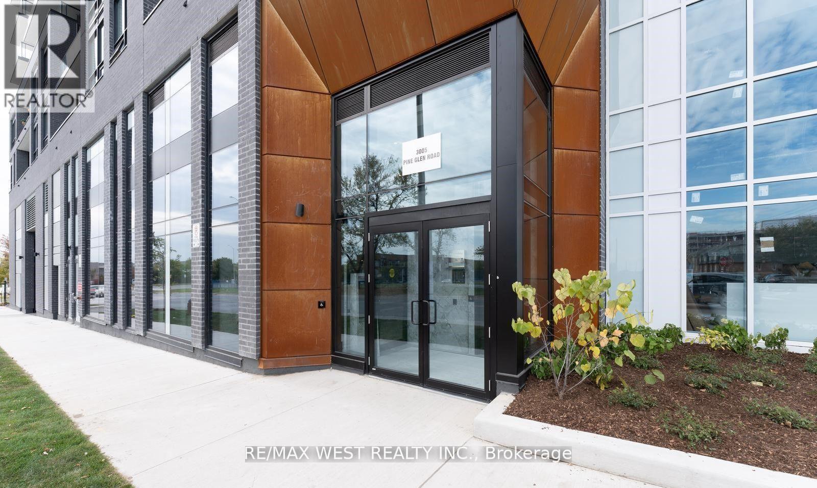 A modern building with a glass door and a sign that says REALTOR.