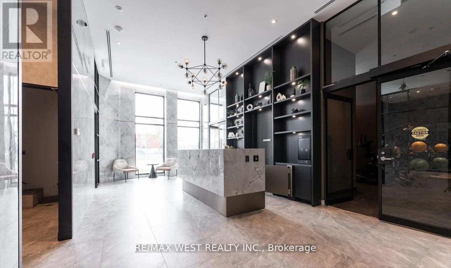 A modern kitchen with a marble countertop and a refrigerator with a glass door.