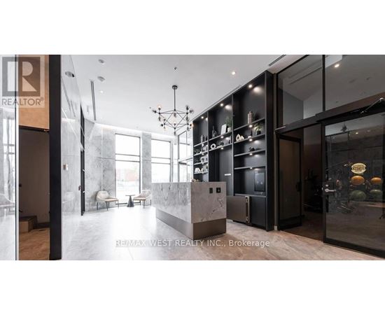 A modern kitchen with a marble countertop and a refrigerator with a glass door.