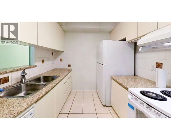 A small kitchen with a white refrigerator and a white stove.