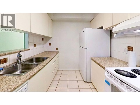 A small kitchen with a white refrigerator and a white stove.