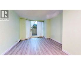 A room with wooden flooring and a window with curtains.