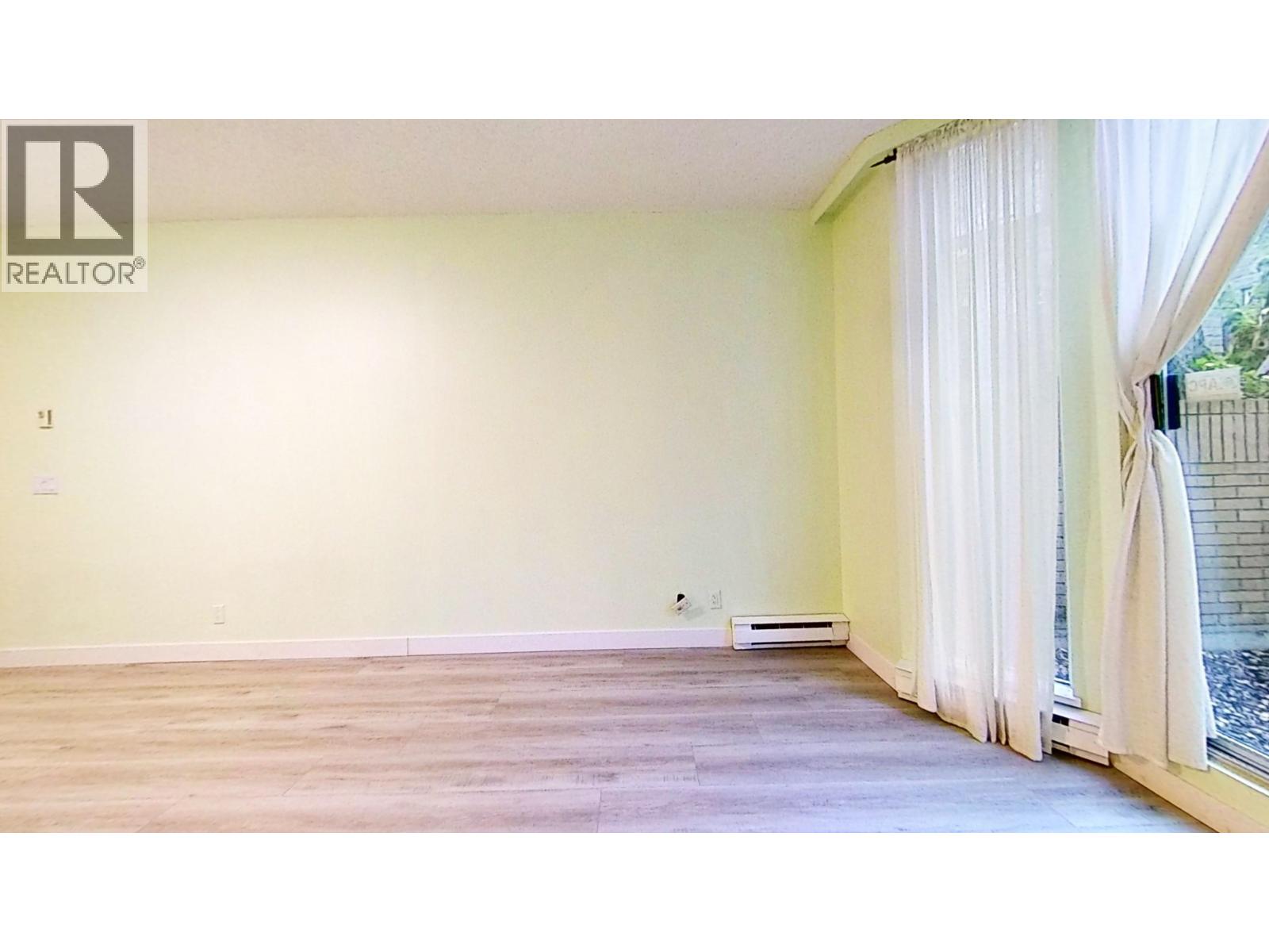 A room with a window and a curtain.