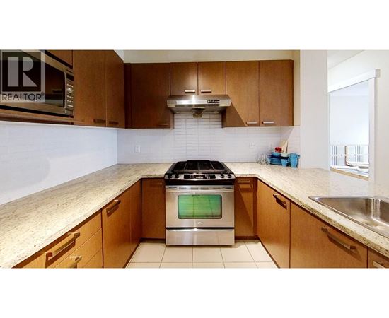 A kitchen with a stove top oven and wooden cabinets.