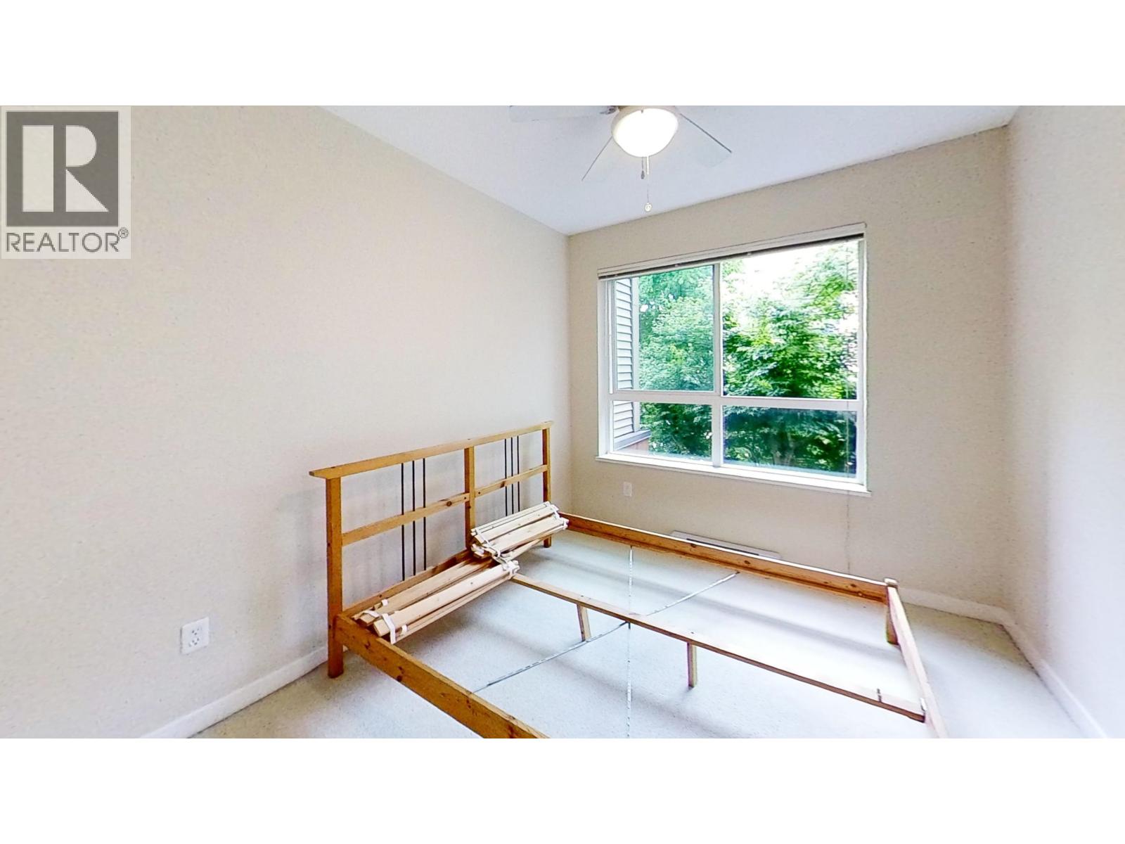 A room with a window and a wooden bench.