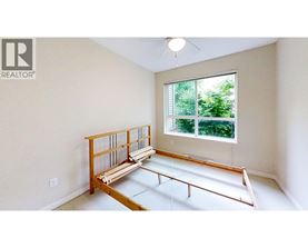 A room with a window and a wooden bench.