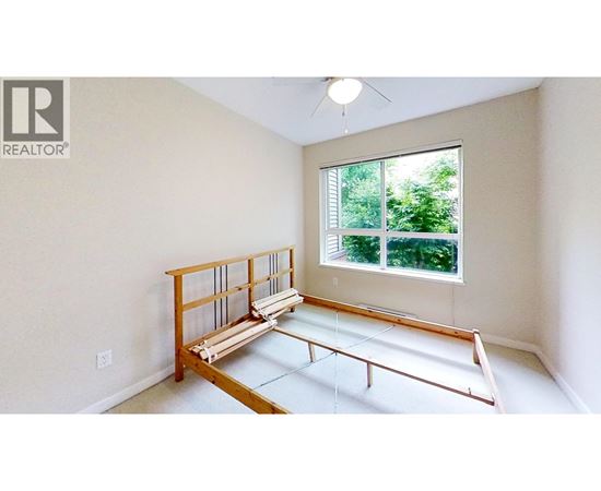 A room with a window and a wooden bench.