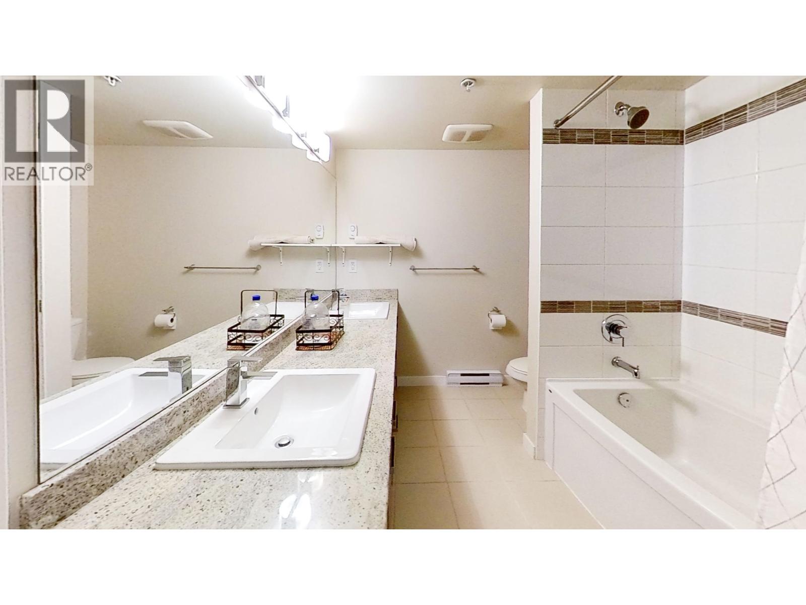 A bathroom with a sink, mirror, and bathtub.