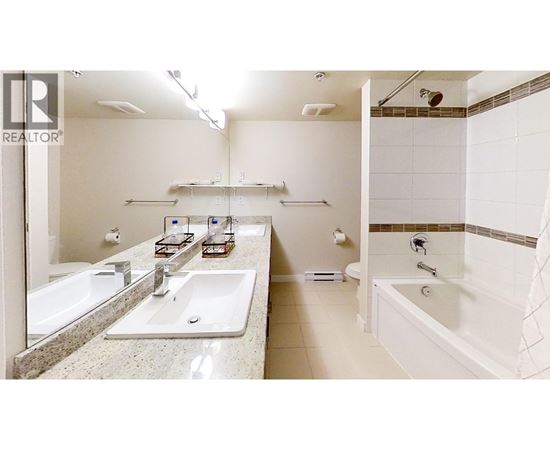 A bathroom with a sink, mirror, and bathtub.
