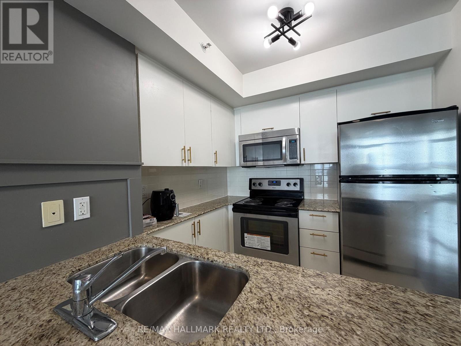 A kitchen with a sink, stove, and refrigerator.