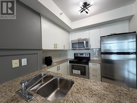 A kitchen with a sink, stove, and refrigerator.