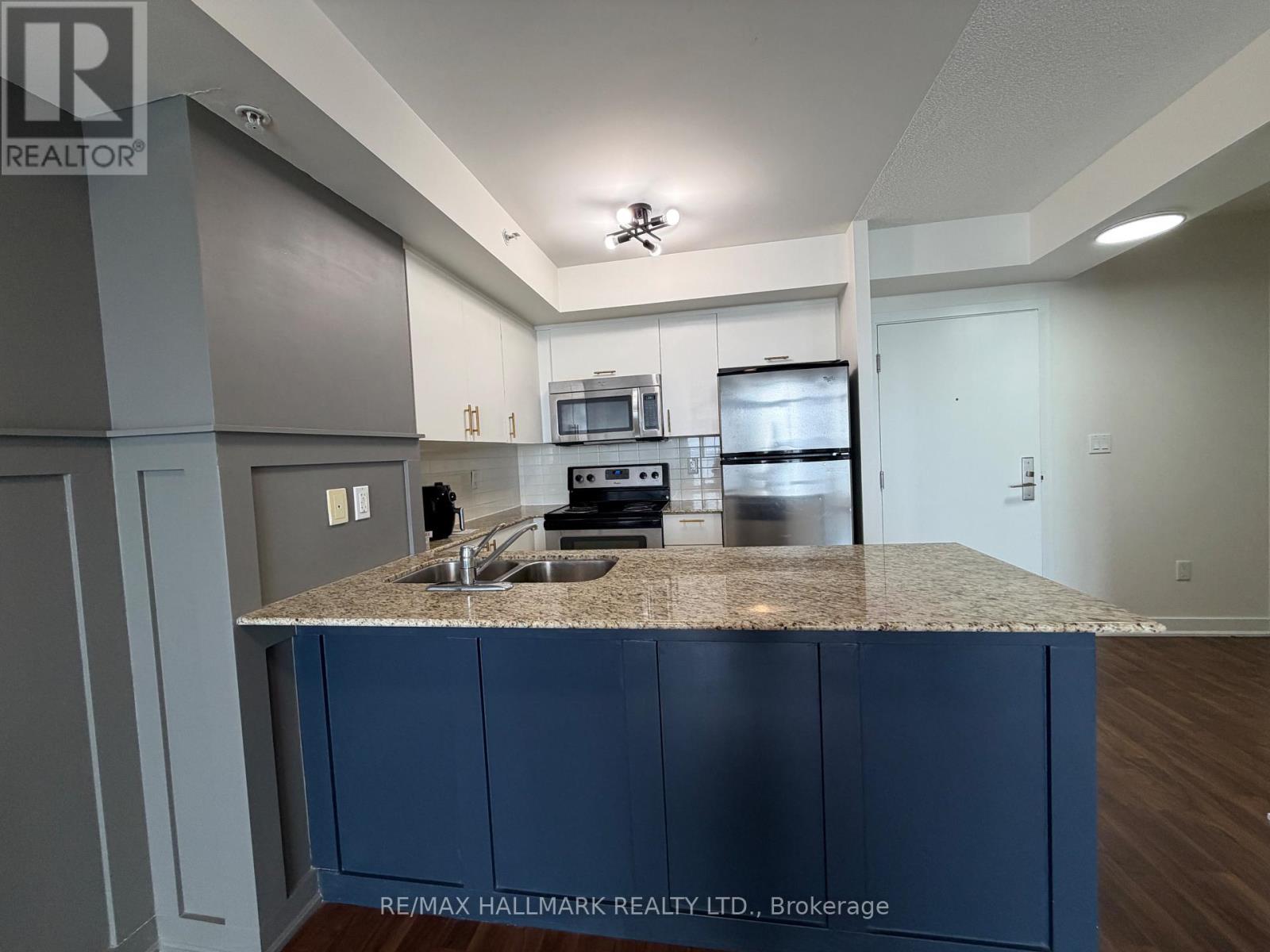 A kitchen with a granite countertop and blue cabinets.