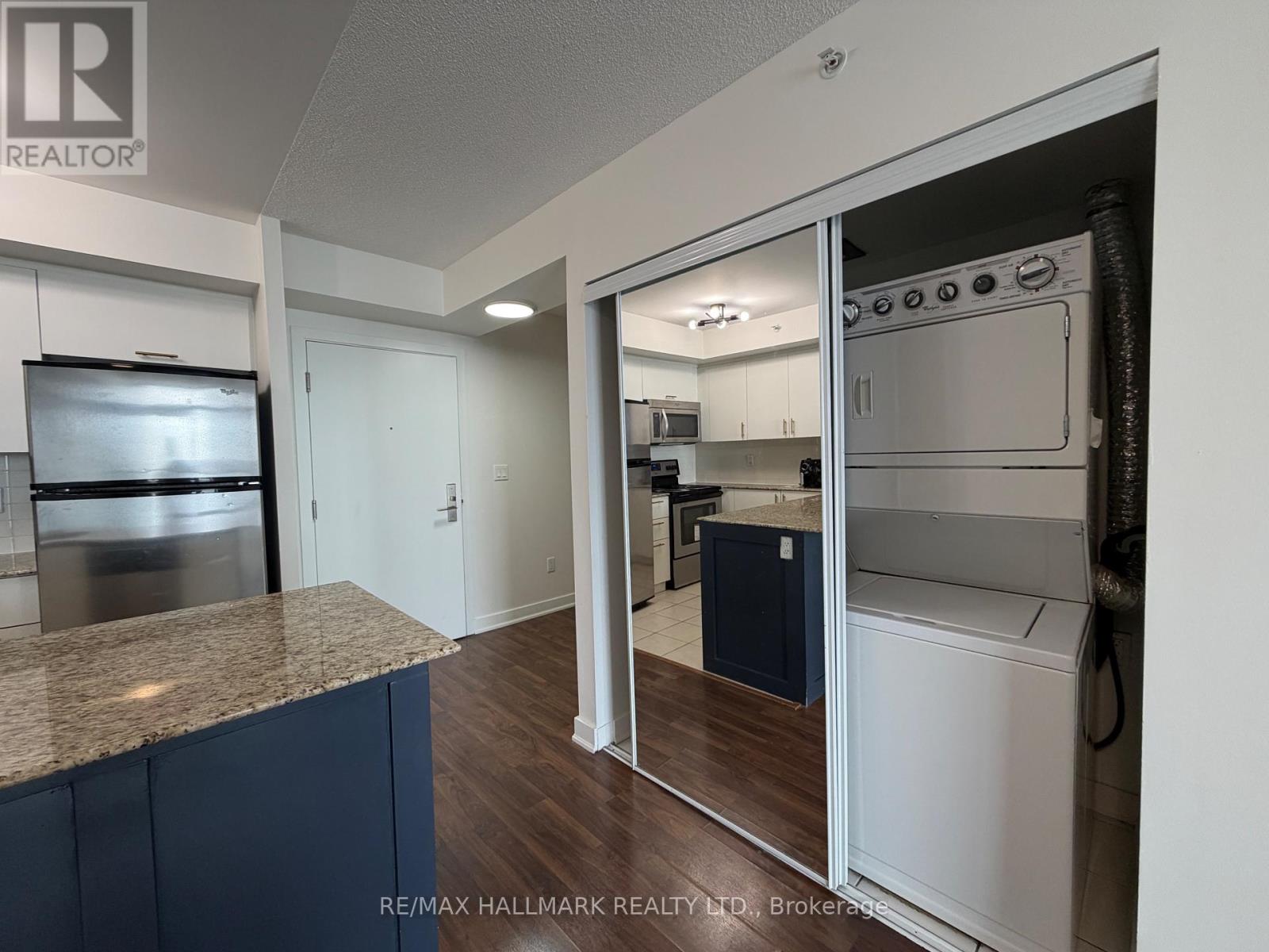 A kitchen with a granite countertop and stainless steel appliances.