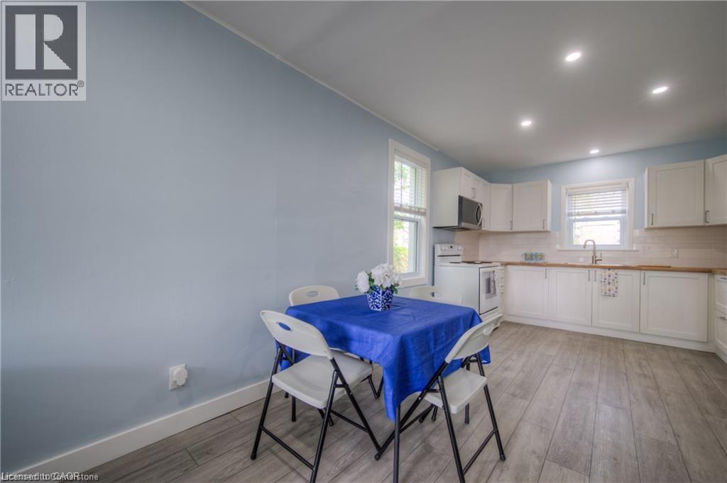 A dining area with a blue tablecloth and white chairs.