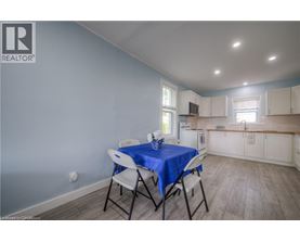 A dining area with a blue tablecloth and white chairs.