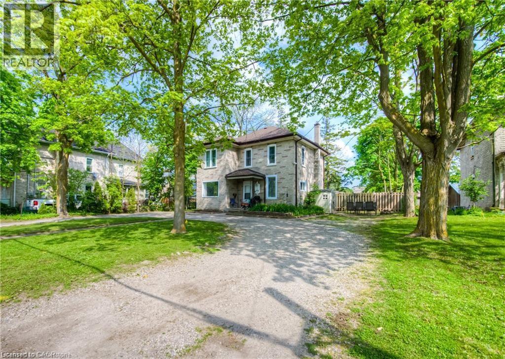 A house with a driveway and trees in front.