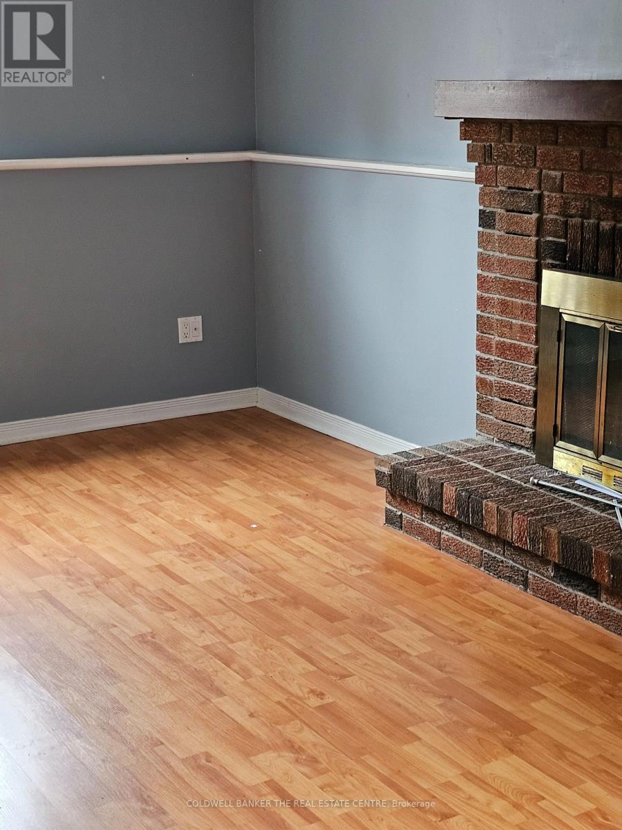 A room with a fireplace and wooden flooring.