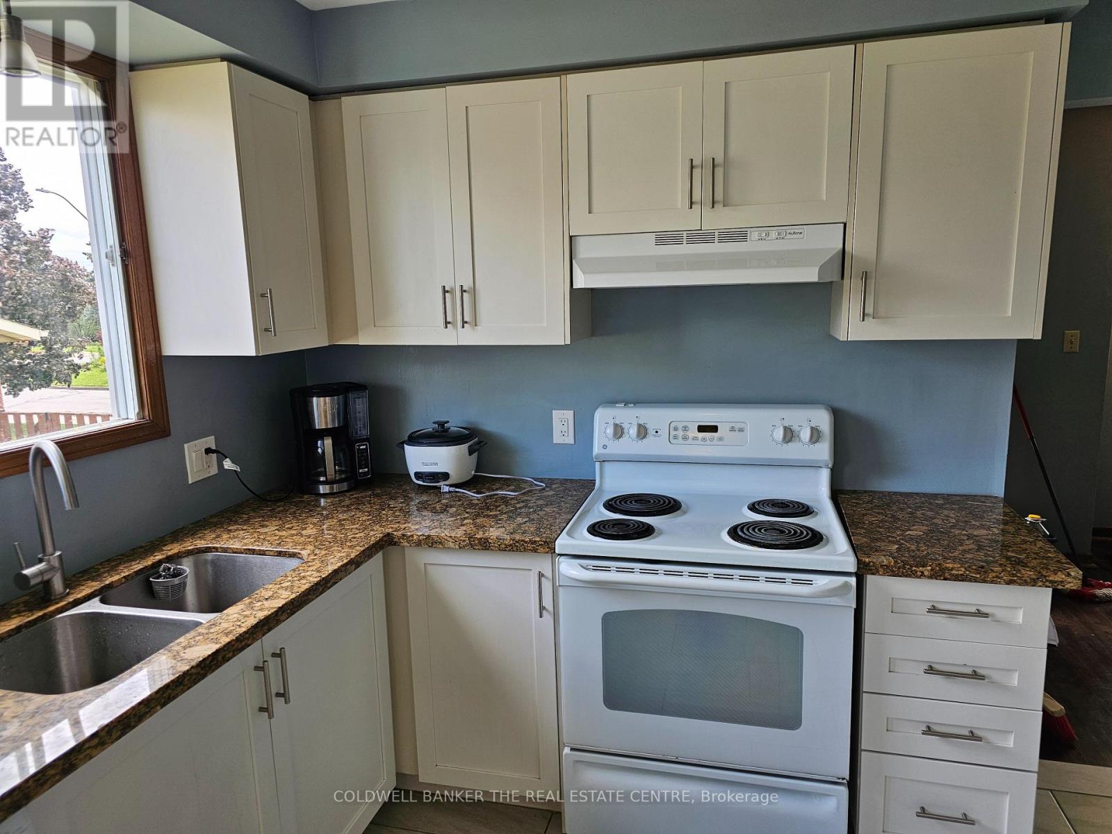 A kitchen with white cabinets and a granite countertop.