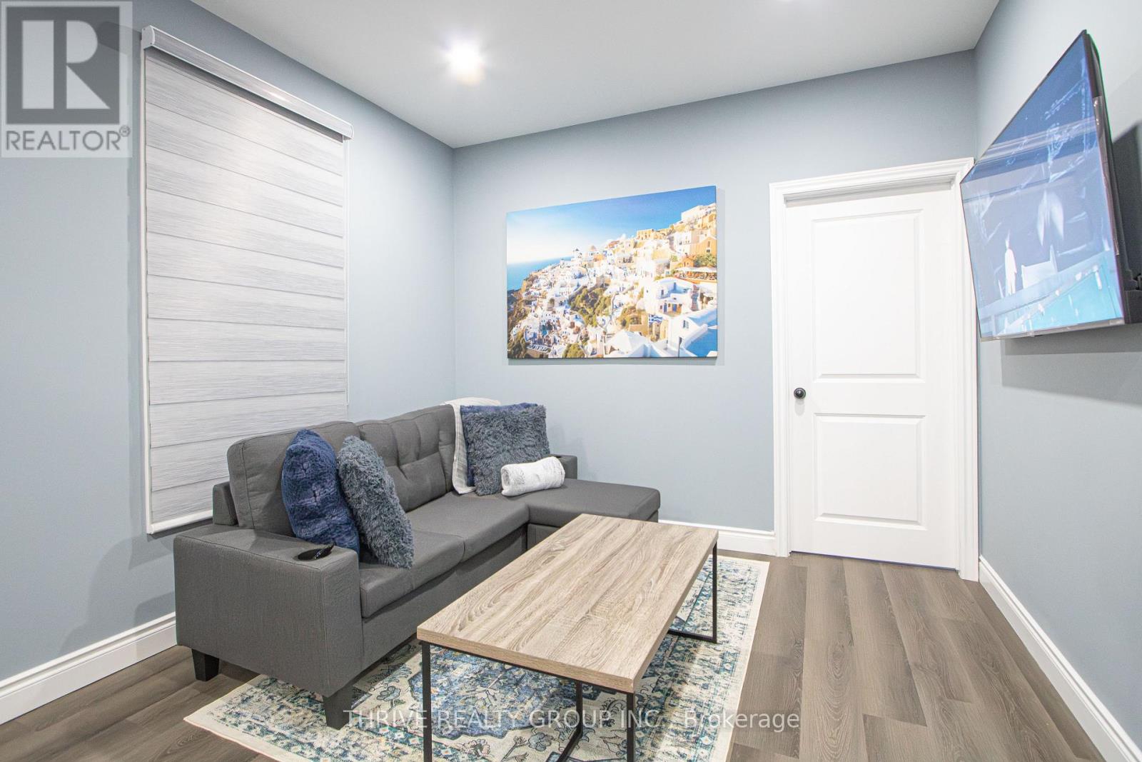 A living room with a grey couch and a wooden coffee table.