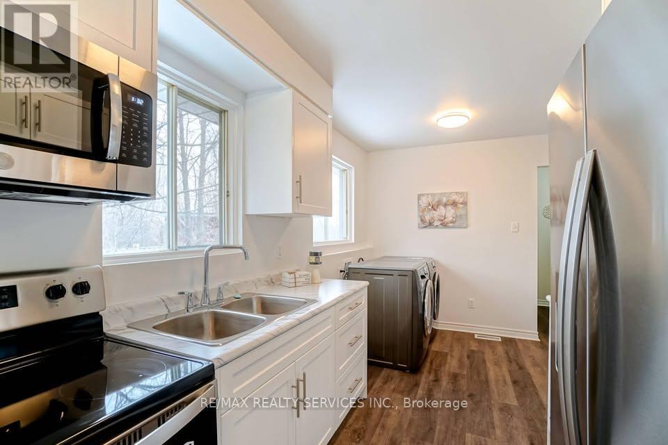 A kitchen with white cabinets and a black stove top oven.