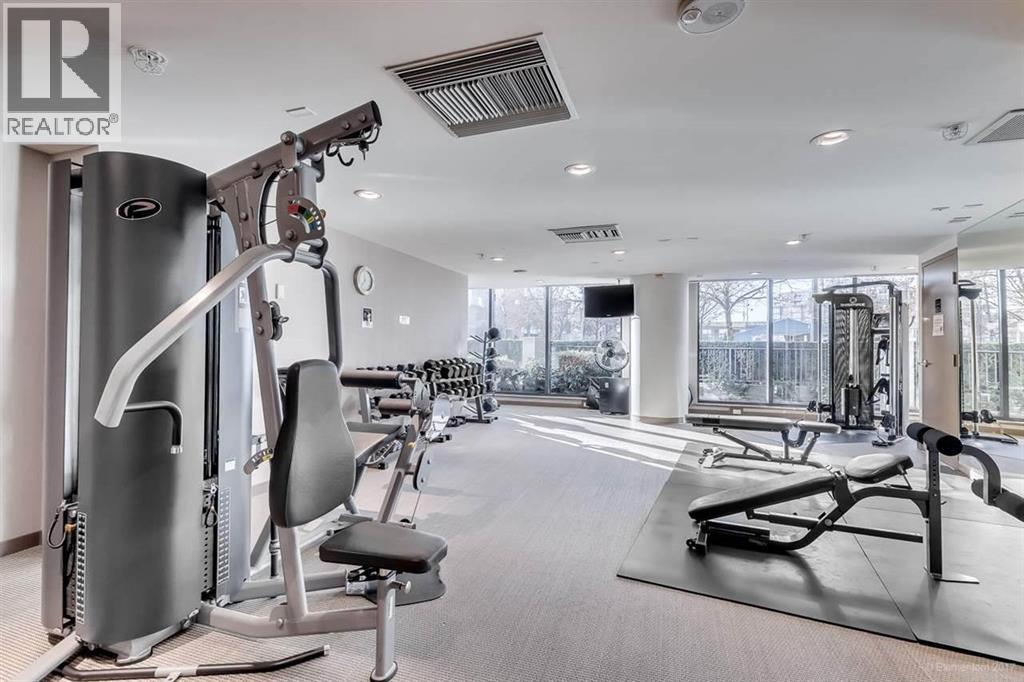 A gym with a variety of equipment including a treadmill, a stationary bike, and a rowing machine.