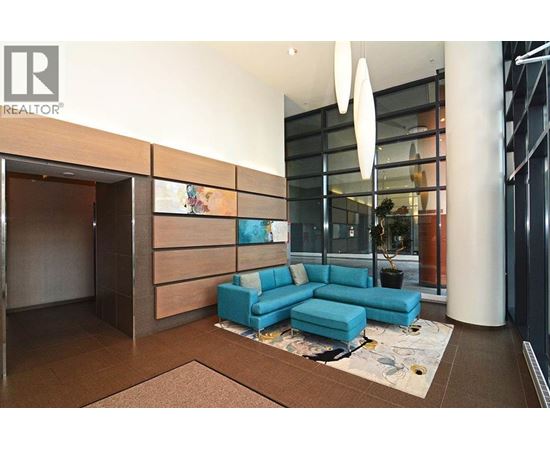 A modern living room with a blue sofa and a glass wall.