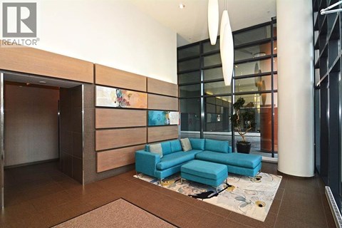 A modern living room with a blue sofa and a glass wall.
