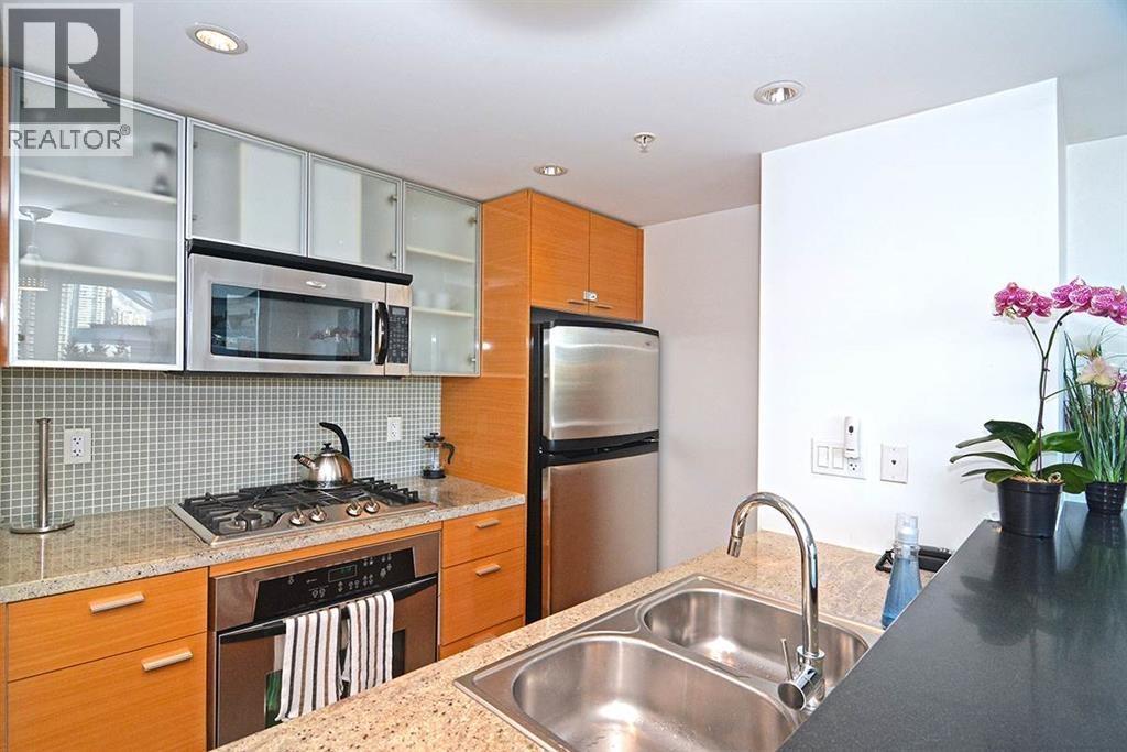 A kitchen with a stove, refrigerator, and sink.