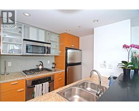 A kitchen with a stove, refrigerator, and sink.