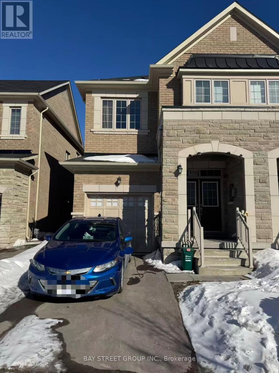 A blue car is parked in front of a house with a sign that says "Bay Street Group, Brokerage.".