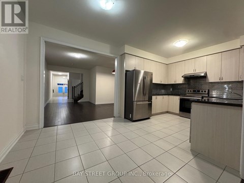 A kitchen with white tiles on the floor and a refrigerator in the middle.