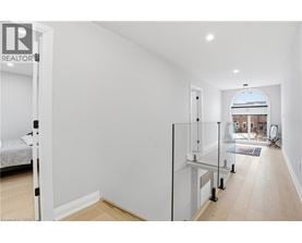 A white bedroom with a glass door leading to a balcony.