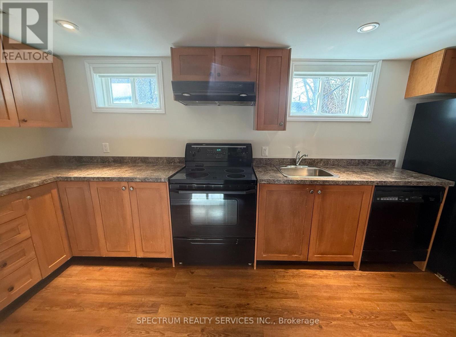 A kitchen with wooden cabinets and black appliances.