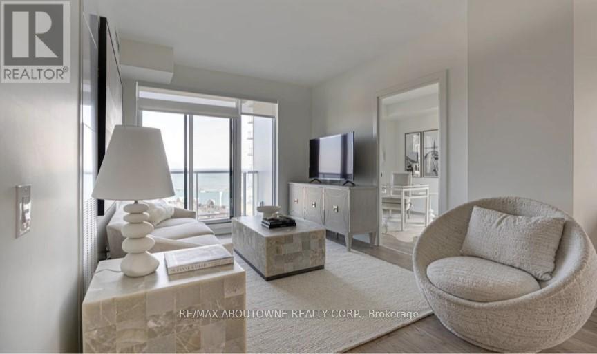 A modern living room with a large window, a flat screen TV, and a comfortable chair.