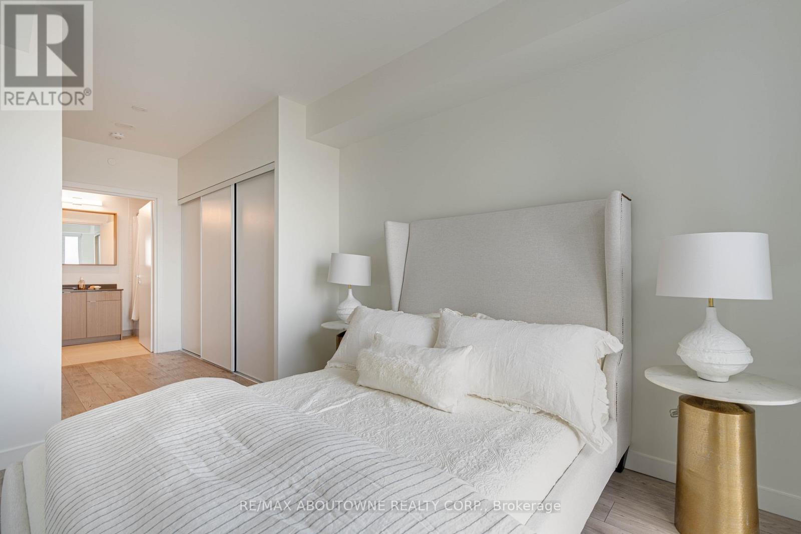 A bedroom with a large bed and two lamps.