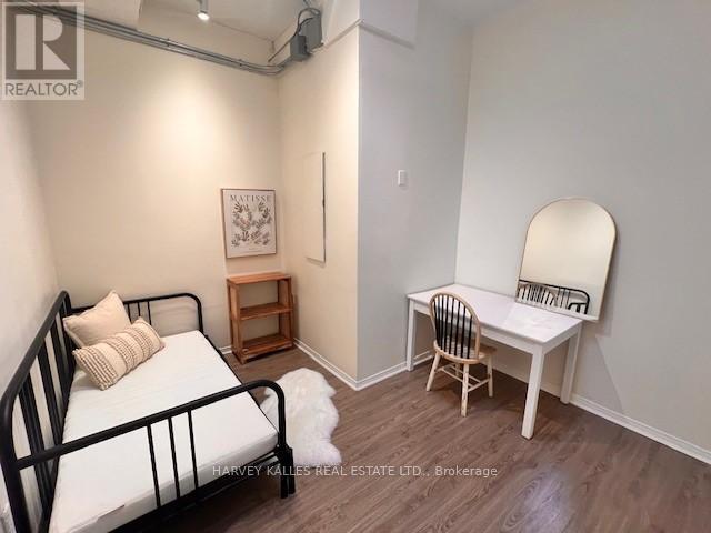 A bedroom with a bed, chair, and a mirror.