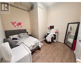 A bedroom with a bed, desk, and chair.