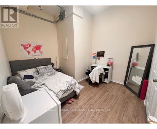 A bedroom with a bed, desk, and chair.