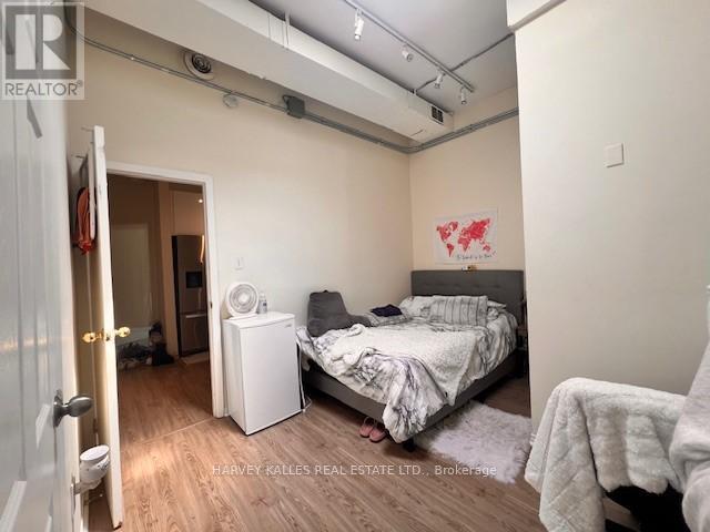 A bedroom with a bed, nightstand, and a wall-mounted air conditioner unit.