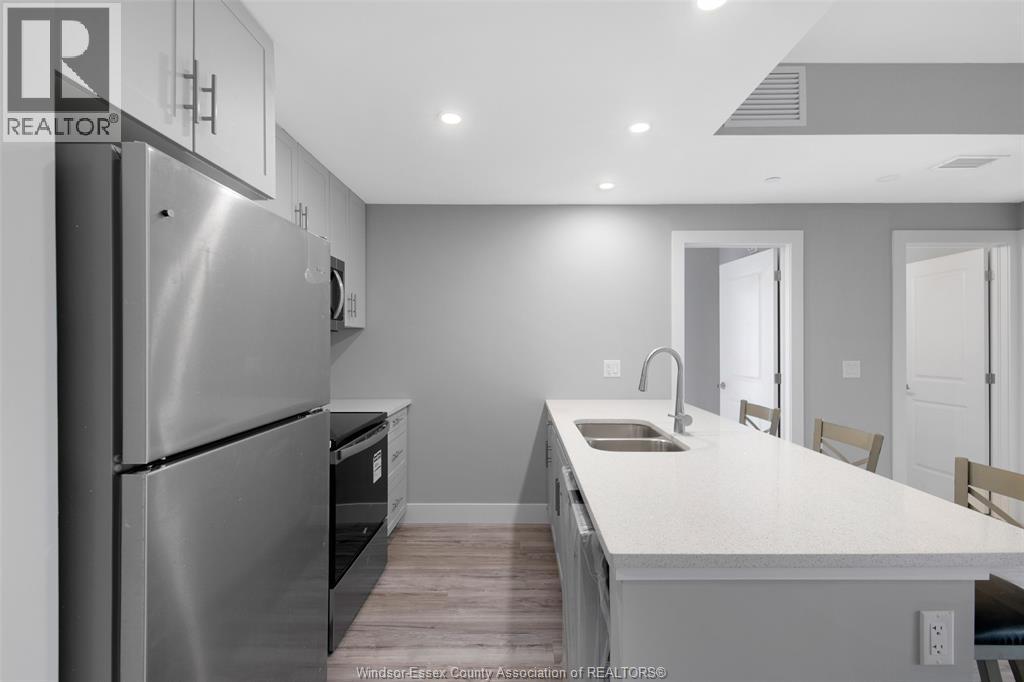 A modern kitchen with a stainless steel refrigerator and a white countertop.