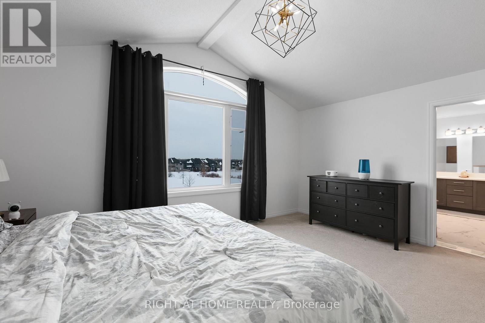 A bedroom with a large bed and a window overlooking a snowy landscape.