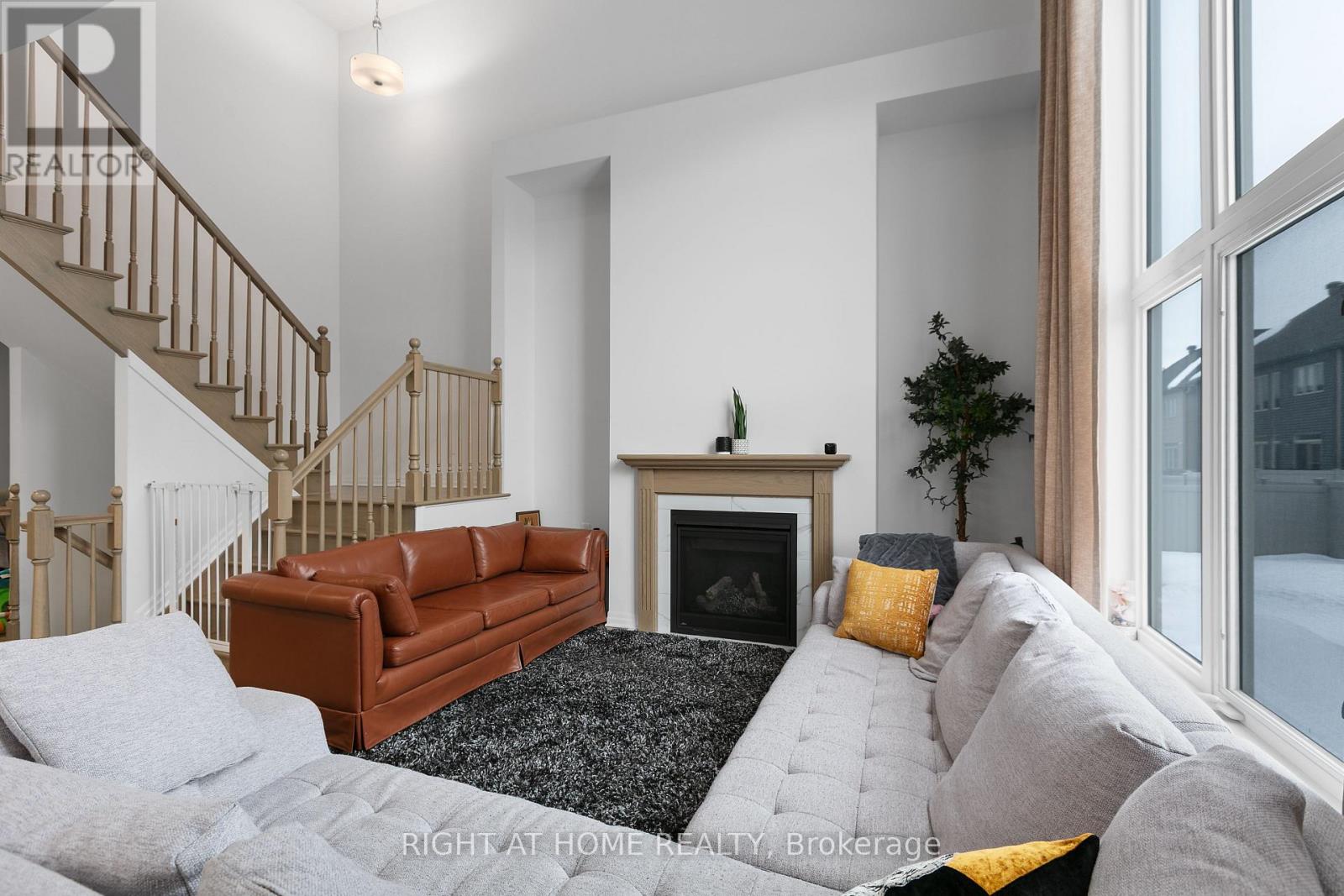 A living room with a grey couch and a brown leather couch.