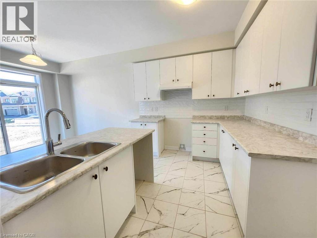 A kitchen with white cabinets and marble countertops.