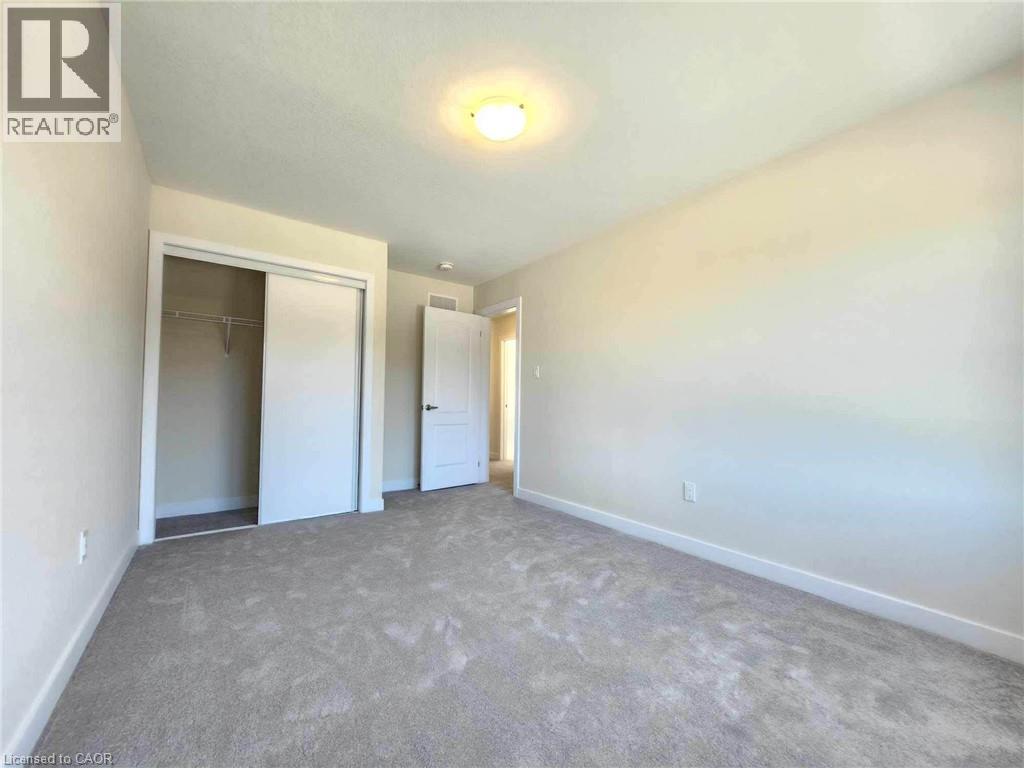 A bedroom with a carpeted floor and two doors.