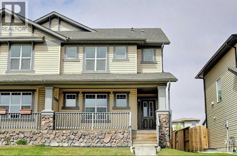 A house with a stone wall and a black door.