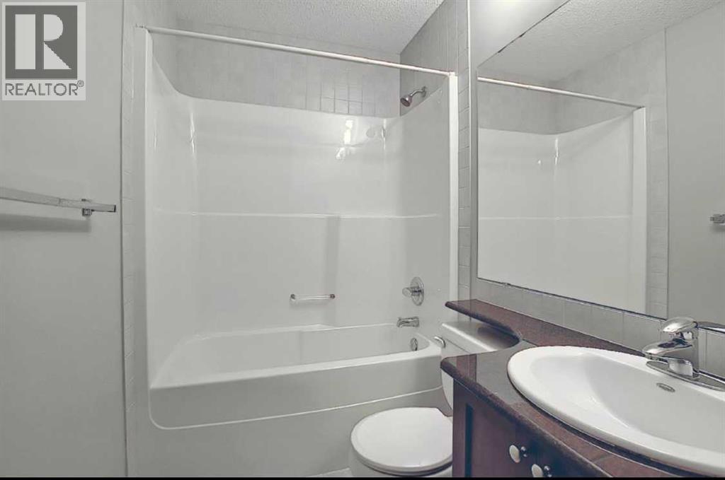A bathroom with a toilet, sink, and bathtub.