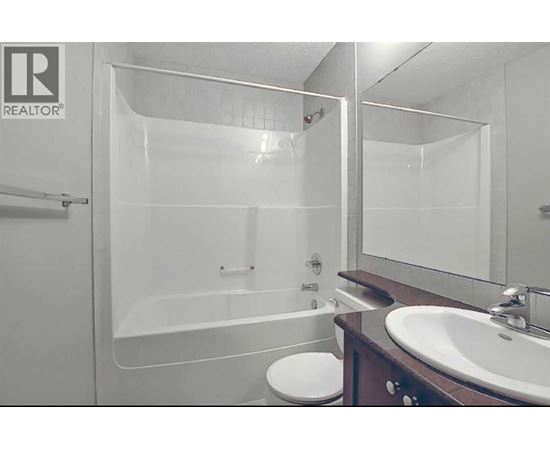 A bathroom with a toilet, sink, and bathtub.