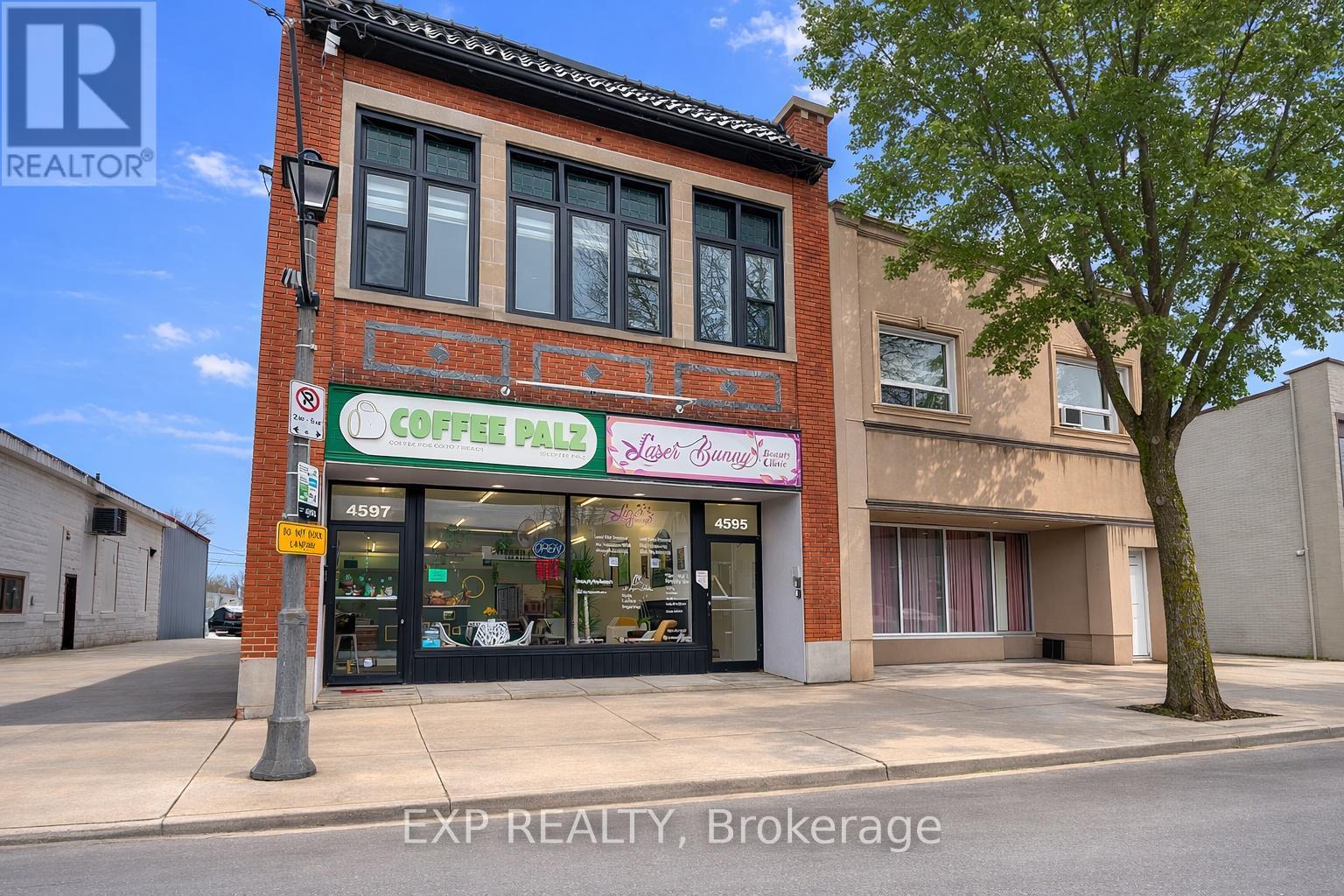 A coffee shop is located in a brick building on a street corner.