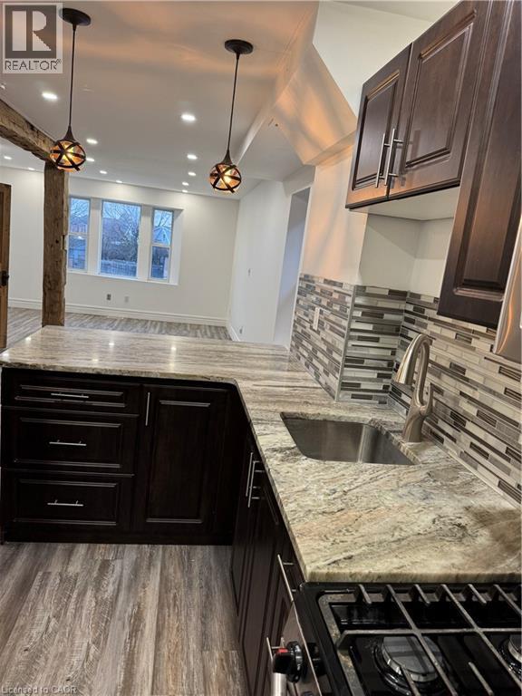 A modern kitchen with dark wood cabinets and a marble countertop.